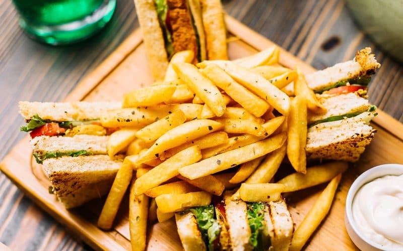 club-sandwich-toast-bread-chicken-tomato-cucumber-french-fries-mayonnaise-ketchup-side-view-lowres